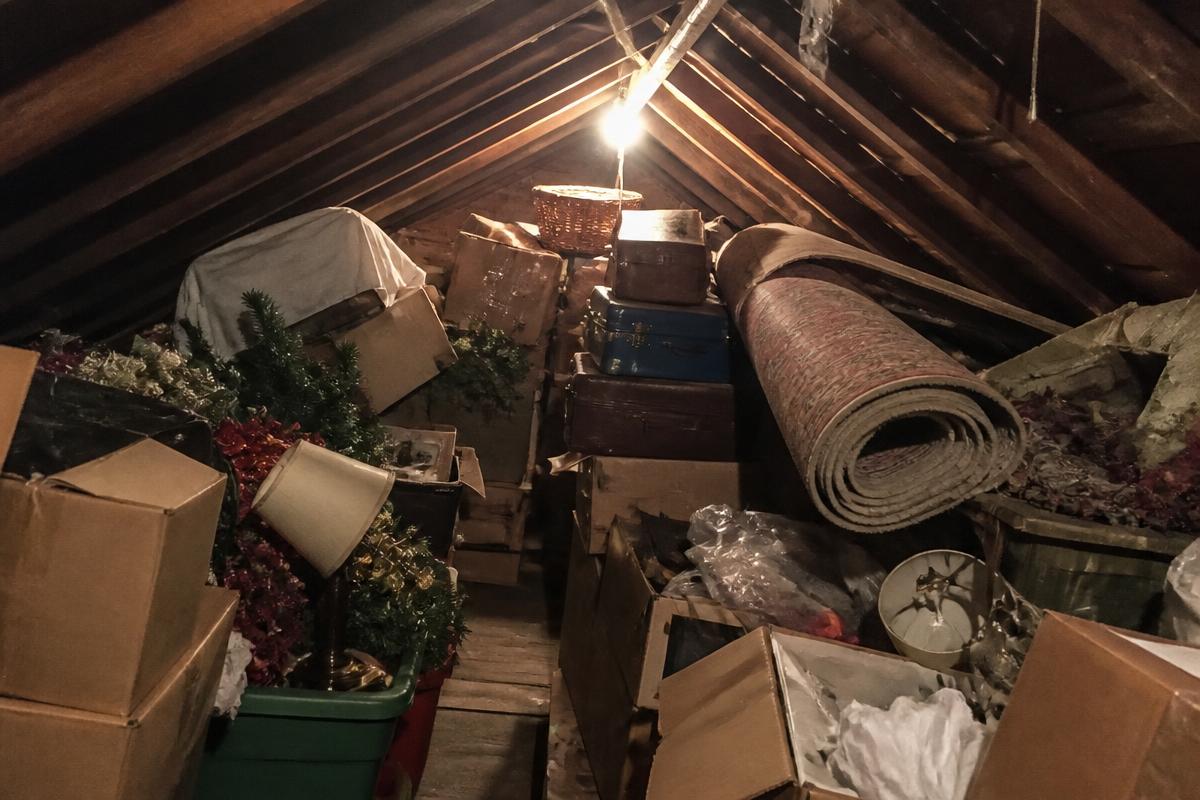 Cramped attic crammed with dusty boxes and old suitcases before cleanout in Rutherfordton, NC